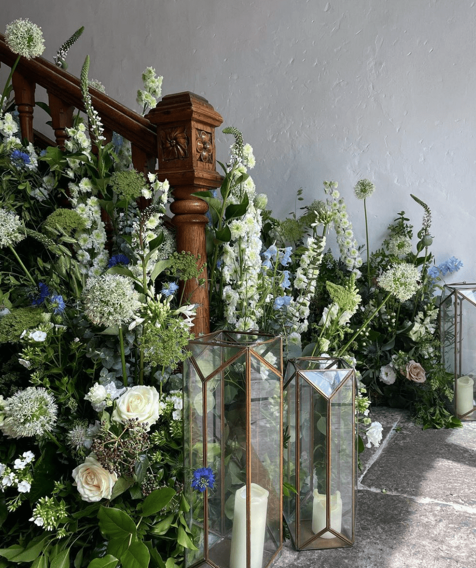 Staircase flowers with delicate lantern holders placed beside the flowers. This floralscape was created for event flowers in London.